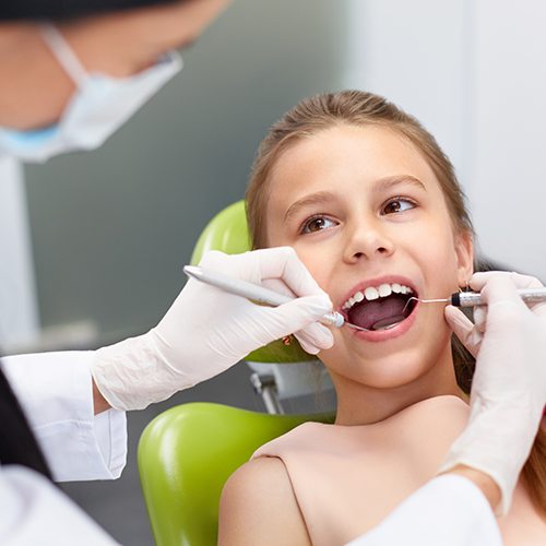 Dentist examining young girl's smile