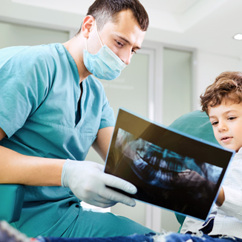 Dentist going over panoramic X-ray with child 