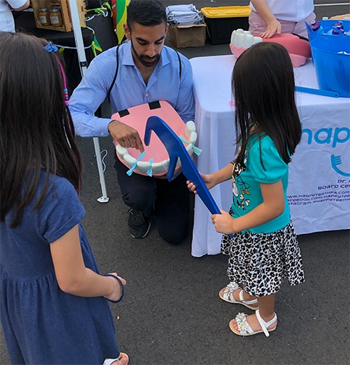 Doctor Singh playing game with kids at a community event