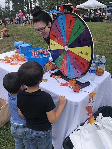 Dental team member talking to two kids at a community event