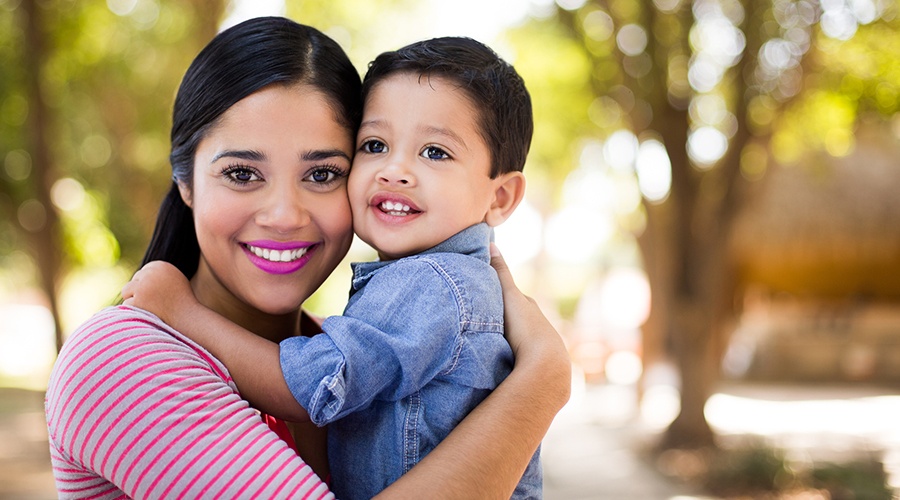 Mother holding child who has healthy smile after cosmetic dentistry