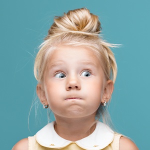 Little girl looking worried after losing a permanent tooth