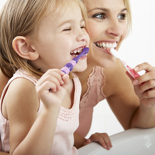 Mother and daughter brushing teeth to prevent dental emergencies