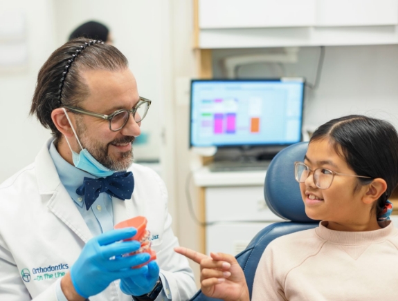 The Happy Teeth Pediatric Dentistry and Orthodontics dental team and dentist at the front desk