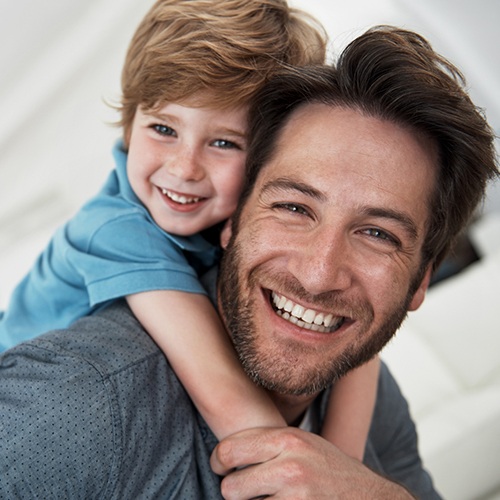 Father and son smiling after visiting the children's dentist