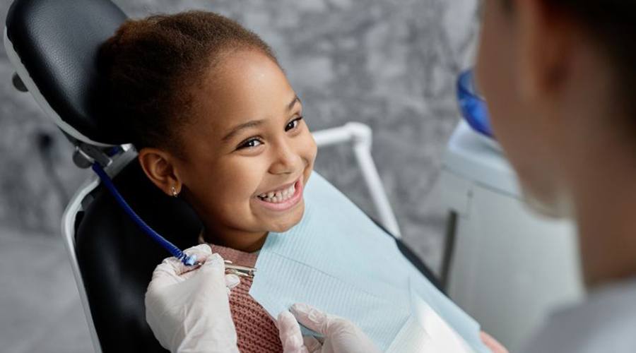 Happy little girl in dental treatment chair
