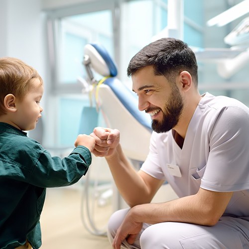 Little boy giving fist bump to his dentist