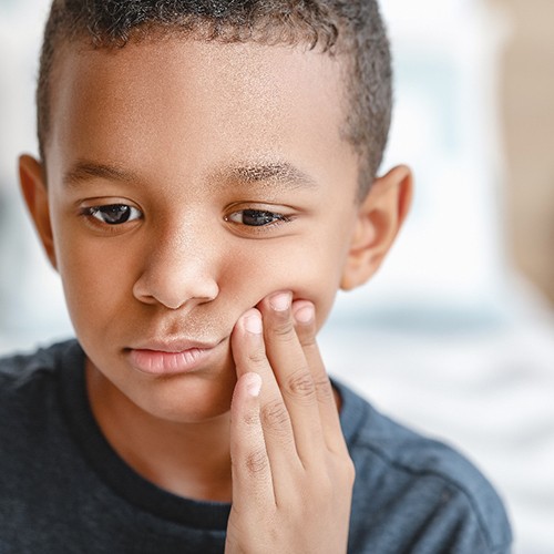 Sad boy suffering from a toothache