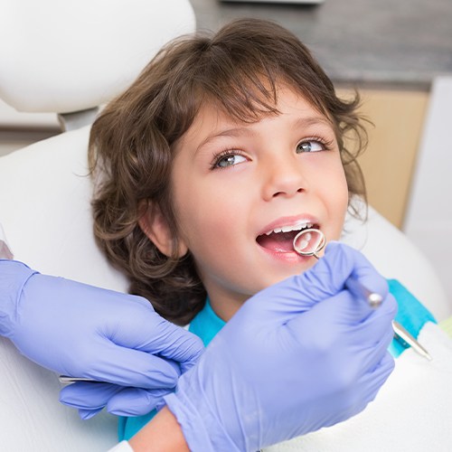 Dentist checking child's tooth colored fillings