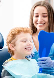 Smiling child pointing to their tooth