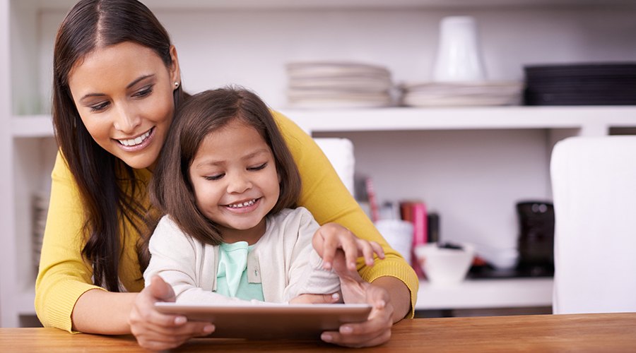 Mother and daughter using tablet computer in dental office