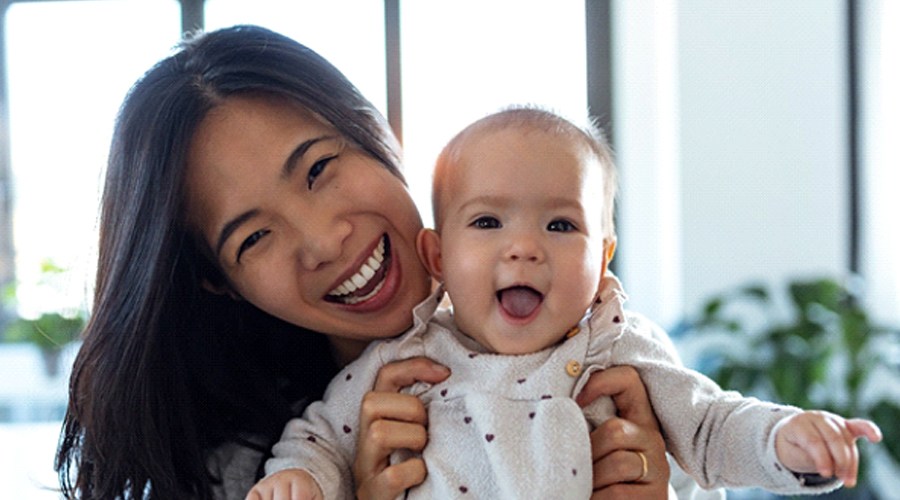 A mother holding her baby who received treatment for a lip tie in Levittown and is now happy