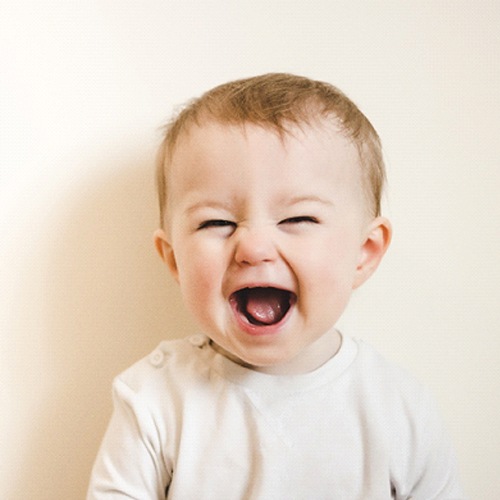 A baby smiling and showing its tongue