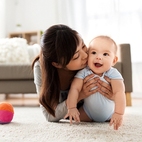 A mother playing with her baby on the floor