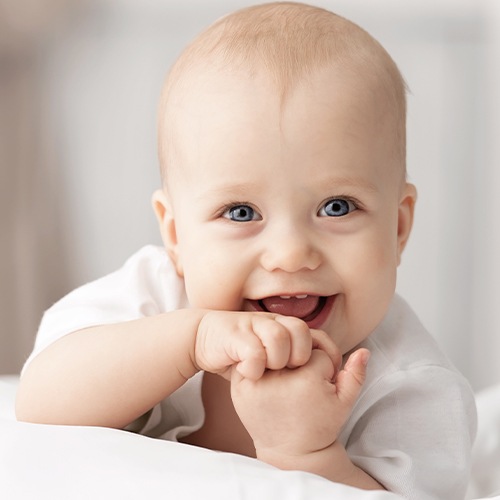 Smiling baby with new teeth after her dentist for infants visit