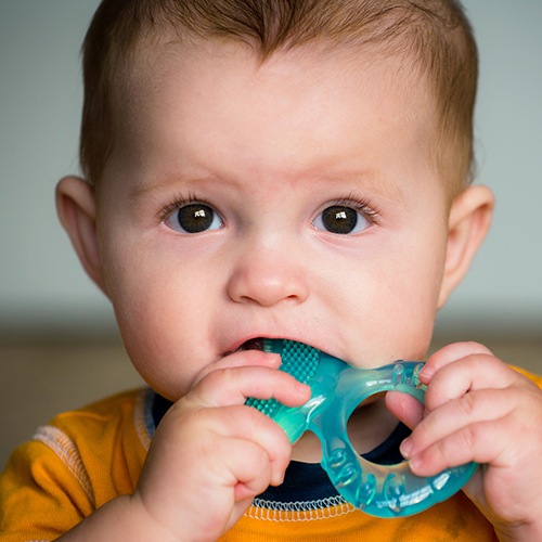 Little boy chewing on teething ring after dentistry for toddlers