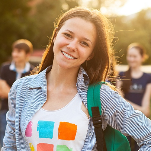 Young woman smiling after receiving dentistry for teens