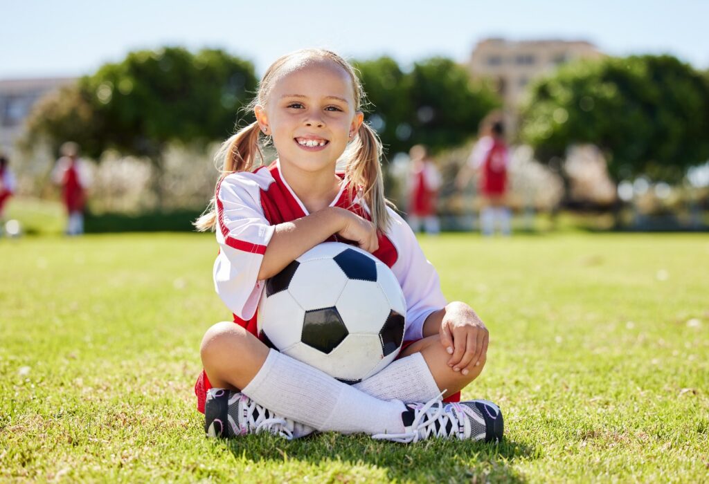 Child smiles with soccer ball