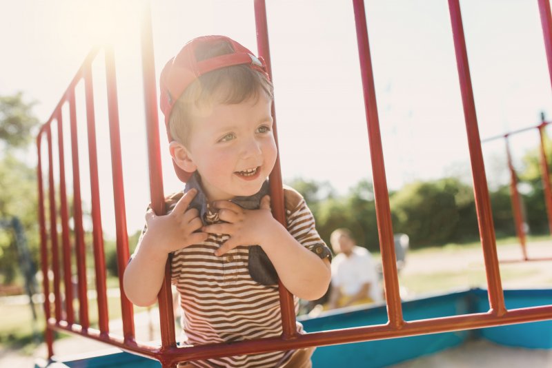 a little boy smiling on the playground